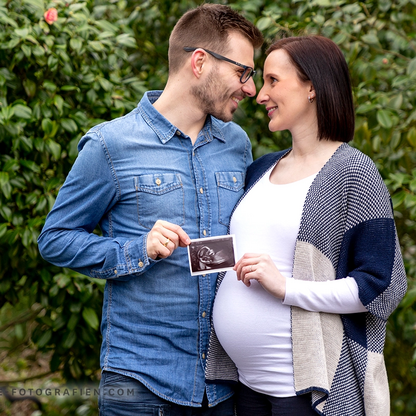 Babybauch_im_Park_mit_Patner_und_Untraschallbild