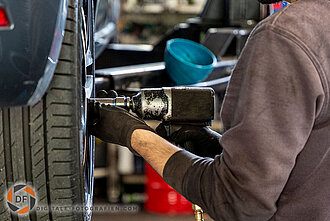 Mechaniker beim Radwechsel in der Werkstatt Radwechsel