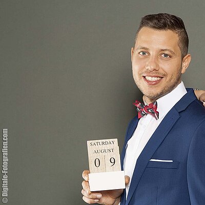 Bräutigam hält Kalender mit dem Hochzeitstag Hochzeitstag