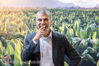 Der Geschäftsführer mit Zigarre in der Hand am Messestand in Dortmund Geschäftsführer