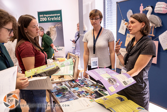 Foto vom Aussteller mit Besuchern an seinem Stand Aussteller