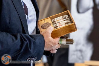 Messebesucher hält eine Schachtel Zigarren in der Hand Zigarren