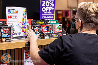 Besucher mit Spielen von Funko in der Hand. Exponate