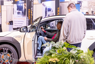 Aussteller zeigt dem Messebesucher das Fahrzeug Fahrzeug